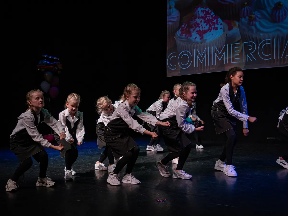 Commercial-groep van Rebounce in witte blouses en zwarte schorten tijdens de eindvoorstelling