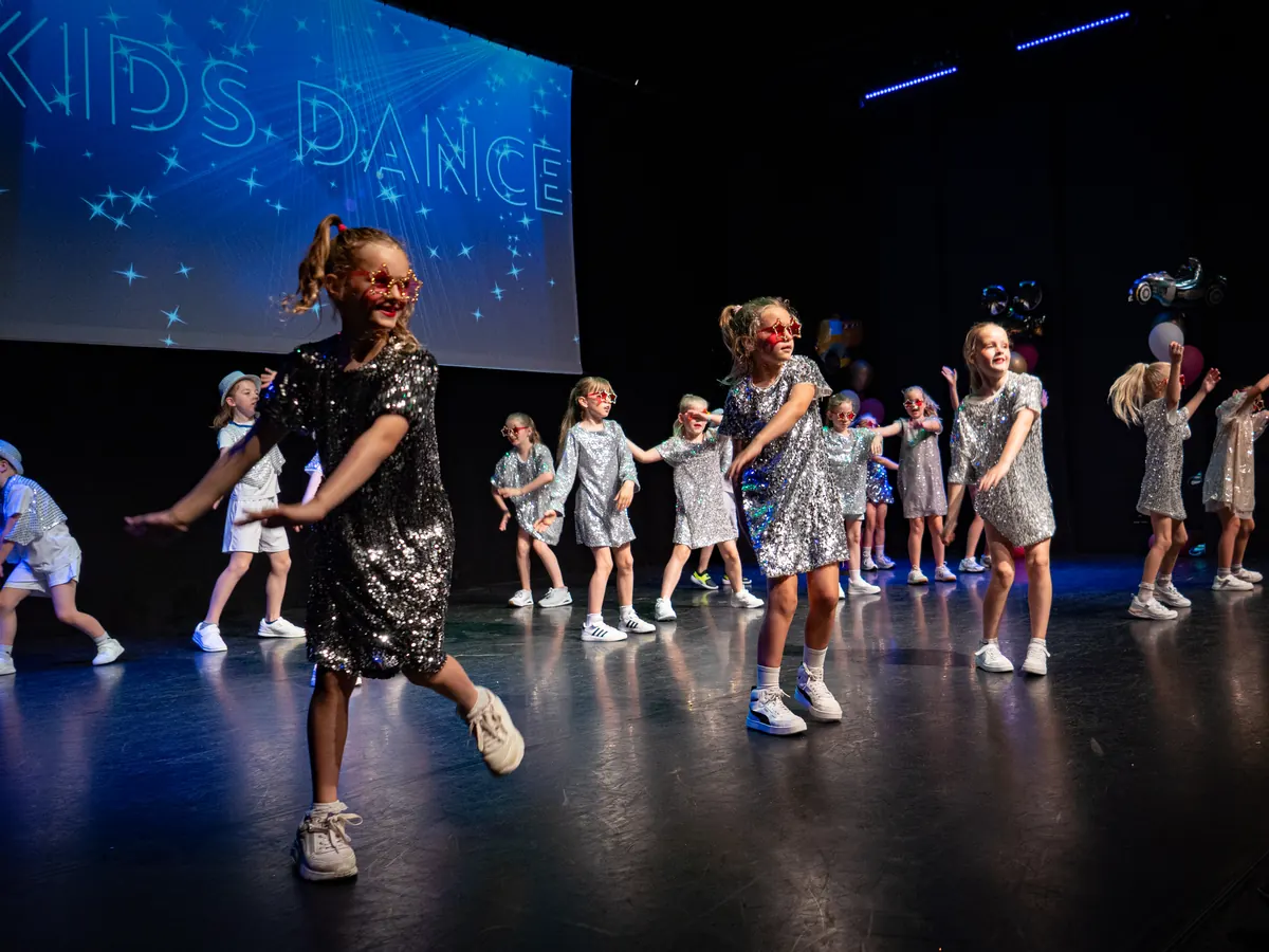 Kids dance-groep van Rebounce in zilveren glitterjurkjes op het podium